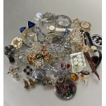 A collection of costume jewelry including paste necklaces, enamel clown brooch, yellow metal