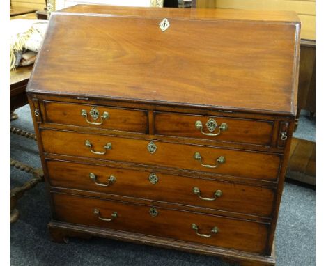 GEORGE III MAHOGANY BUREAU, angled fall enclosing fitted interior with later carved drawers and cupboard, above five drawers,