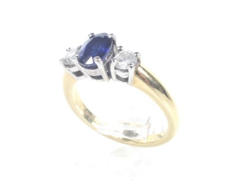 A modern 18ct white and yellow gold, sapphire and diamond three stone ring. Centred with an oval native-cut sapphire approx. 