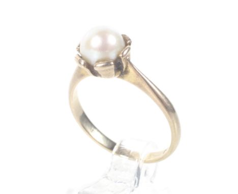 A vintage 9ct gold and cultured-pearl single stone ring. The 6mm diameter cultured-pearl in a broad-claw setting on a D-secti