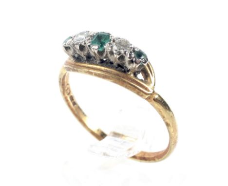 A mid-20th century gold, emerald and diamond five stone ring. The three small emeralds (one probably a replacement green past