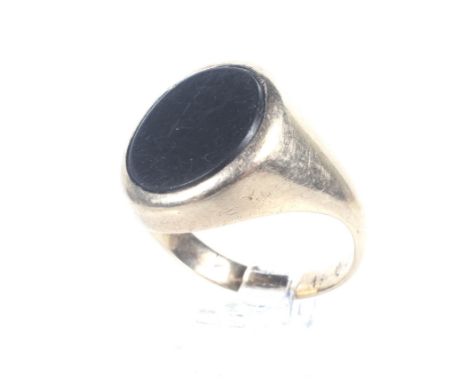 A vintage gold and black onyx oval signet ring. The plain oval black-onyx panel rub-over set on a tapering shank stamped '9ct