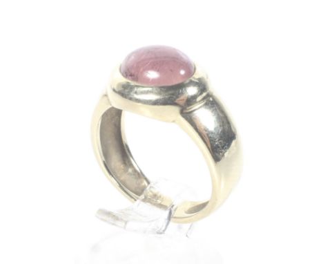 A vintage German tourmaline single stone ring. The oval cabochon pink tourmaline rub-over set in yellow to a tapering shank s