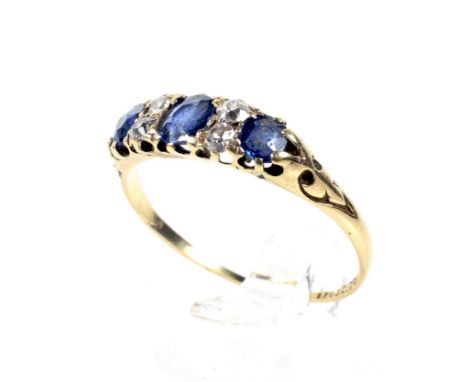 A late Victorian 18ct gold, sapphire and diamond stone ring. The three graduated oval French-cut sapphires spaced by pairs of