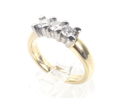 A modern 18ct white and yellow gold and diamond three stone ring. The three round brilliants approx. 0.54cts total, in white 