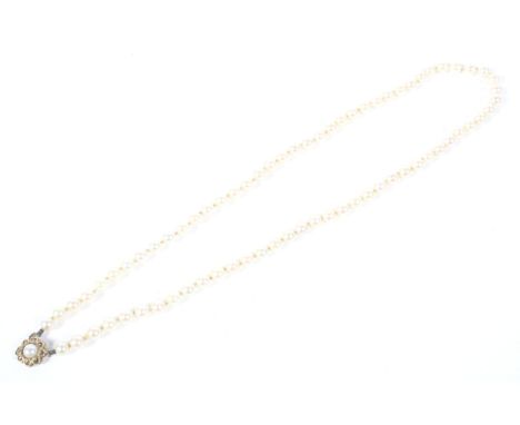 A Mikimoto cultured-pearl single row necklace. The 72 uniform 5.5-5.75mm diameter round beads, knotted on a yellow metal and 