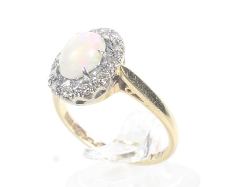 A vintage 18ct gold opal and diamond and oval cluster ring. Centred with an oval cabochon white opal, claw set within a tiny 