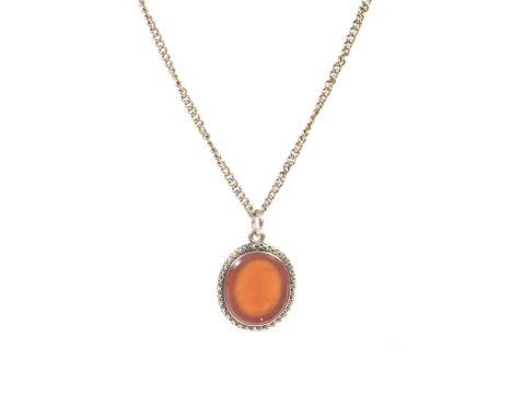 A vintage gold necklace and carnelian pendant. The curb-link chain on a bolt-ring clasp stamped '9ct'and hung with a shallow-