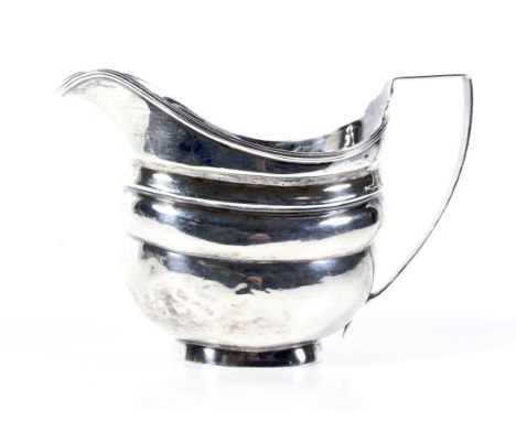 A George III English provincial silver oblong milk jug. With a reeded rim, scroll handle and bracket foot, mark of George Mur