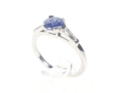 A 1920's platinum, sapphire and diamond ring. Centred with a pale pastel-blue round mixed-cut sapphire approx. 0.73cts, in a 