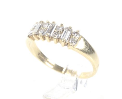 A vintage 18ct gold and diamond dress ring. The three baguette diamond spaced by pairs of small round brilliant diamonds, all