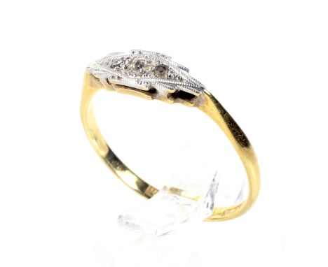 An early 20th century gold and small diamond three stone ring. The graduated eight-cut stones grain set in a shaped platinum 