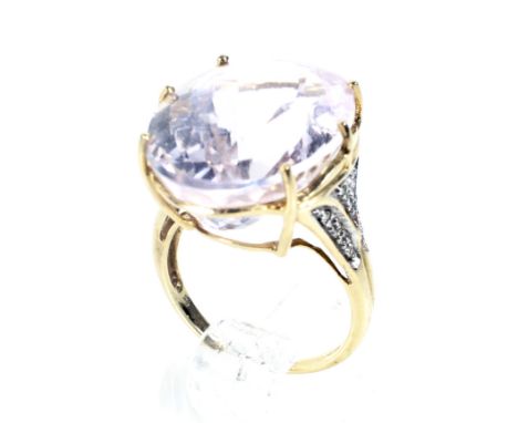 A modern 9ct gold, kunzite and diamond dress ring. Centred with an oval mixed-cut kunzite, approx. 20mm x 15mm x 11mm, claw s