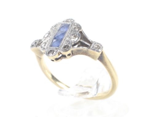 An Art Deco sapphire and diamond shaped-oval cluster ring with diamond shoulders. The central cluster with a central calibre 