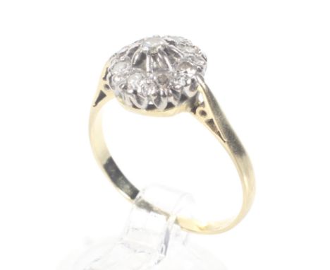 A mid-20th century 18ct gold and diamond cluster ring. The nine single and eight-cut stones claw set in white on a yellow D-s