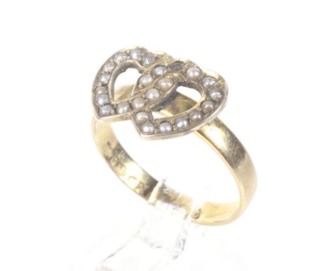 A late Victorian 18ct gold and half-pearl entwined twin-hearts ring. The open hearts later applied to a D-section shank with 