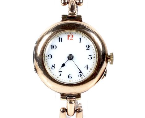An early 20th century lady's 9ct rose gold round bracelet watch, circa 1914. The white enamel dial with a red 12 and black Ar