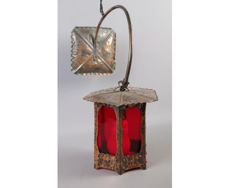 A hanging beaten copper wall light with red Perspex screening.  