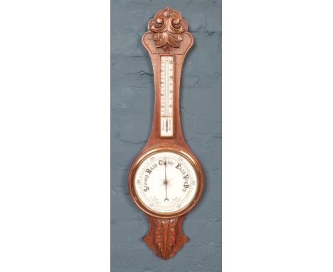 A carved oak banjo aneroid barometer, with foliate detailing to top and bottom. 81cm high.  
