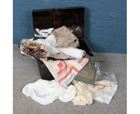 A dome top tin trunk with contents of various linens, baby clothes etc.  