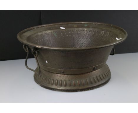 A large copper planter with decorative brass banding. 