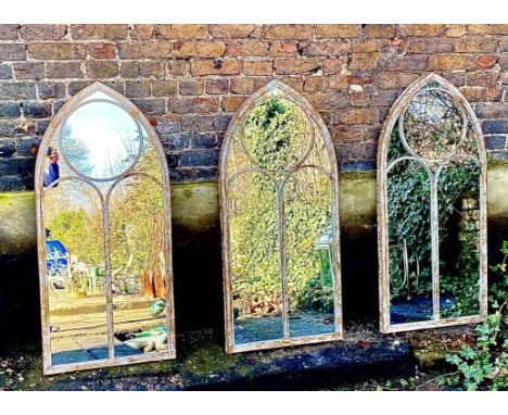 ARCHITECTURAL GARDEN WALL MIRRORS, a set of three, aged metal arched frames, 122cm H x 56ckm W. (3) 
