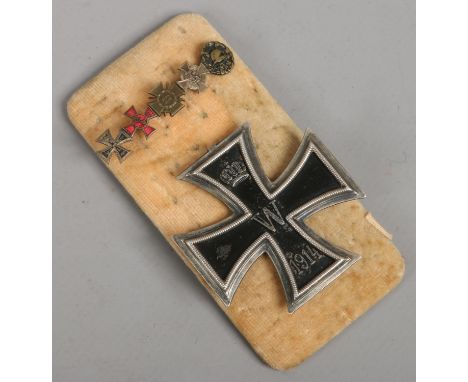 A World War I German iron cross and a miniature group of five enamel medals on stick pin.