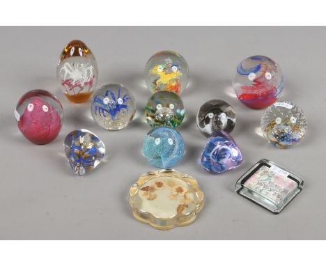 A collection of thirteen decorative glass paperweights to include Caithness and Cowdy.