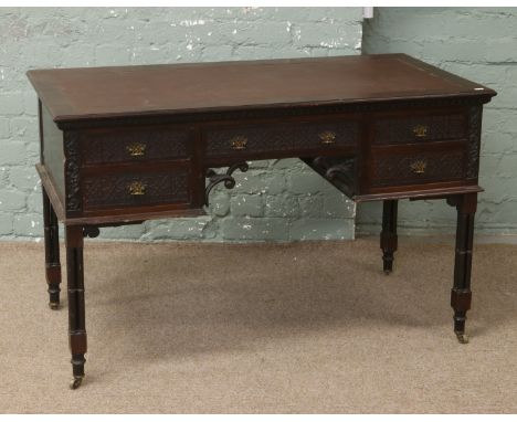 A Victorian Chinese Chippendale mahogany leather top desk, raised on cluster supports.