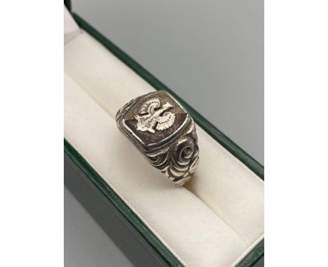 A Vintage military style signet ring detailing a crowned phoenix. Stamped IR. Also stamped to the inside of the ring as well.