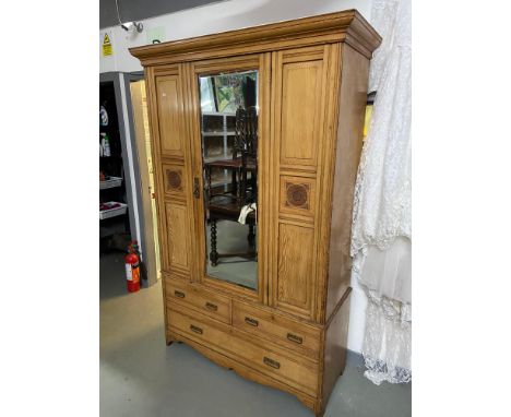 A Large Victorian light oak single mirror door wardrobe. Designed with hook interior and two over 1 chests. 