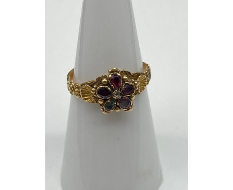 A 19th century ladies gold ring set with various gem stones. Off set by a gold shell to each shoulder. Stones include Emerald