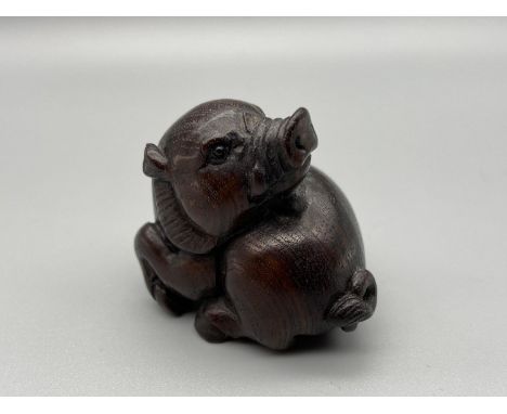 Japanese hand carved netsuke of a boar designed with black bead eyes and signed by the artist. [4cm] 
