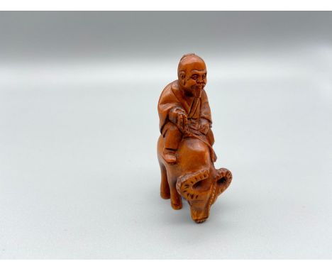 Japanese hand carved netsuke of a gentleman riding an ox, signed by the artist [5.2cm] 