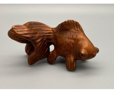 A Japanese hand carved netsuke of a blackmore fish detailed with black bead eyes. Signed to the base by the artist. [6.5cm] 