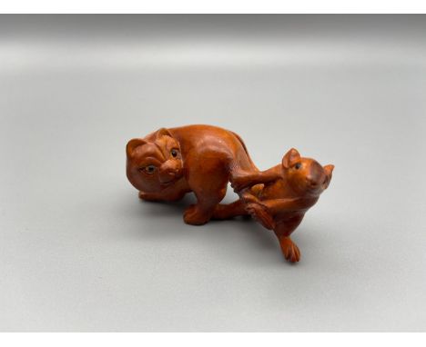A Hand carved Japanese netsuke of a mouse pulling a cat tail. Signed by the artist. Both detailed with black bead eyes. [5.5c
