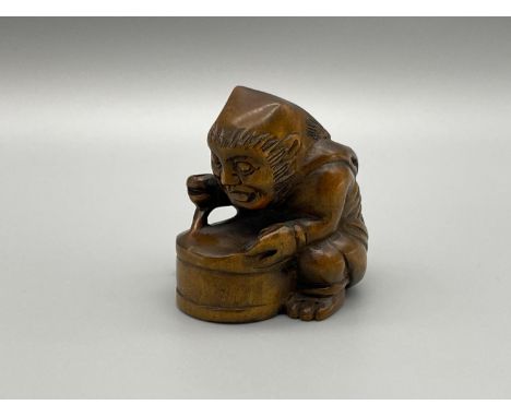 A Japanese hand carved netsuke of a Oni Monster stirring his potion. 