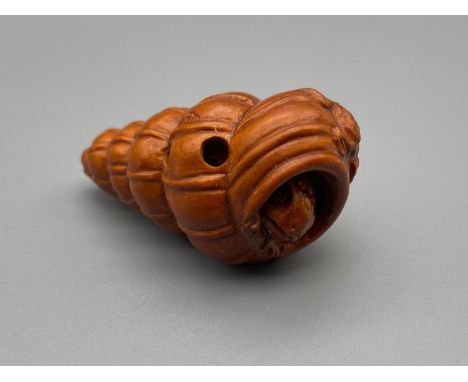 A hand carved Japanese netsuke of a toad with a shell with another baby toad st on top. Both detailed with black bead eyes. S