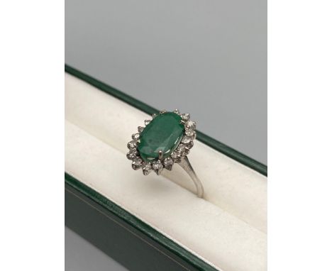 Antique Foreign white gold ladies ring set with a large emerald surround by diamonds. Stamped to the outside of the band. [Ri