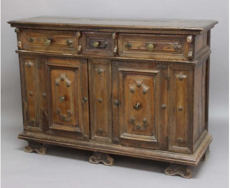 ITALIAN WALNUT CABINET, perhaps 18th century, with three fielded panel drawers above a pair of cupboards with brass mounts, o