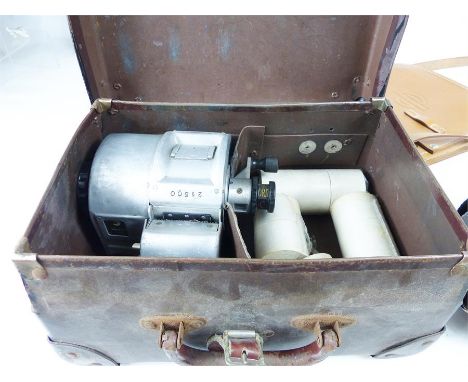 A vintage bus conductor's ticket machine with case, a London Transport shoulder bag and London Bus driver's badge.