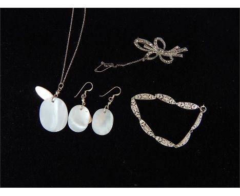 A silver bracelet, a brooch with a matching silver and mother of pearl pendant on chain and earrings.