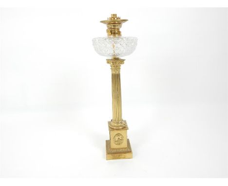 A 19th century, gilt, brass and cut crystal lamp with a reeded Corinthian column stem, squared, plinth base. Height: 65 cm. (