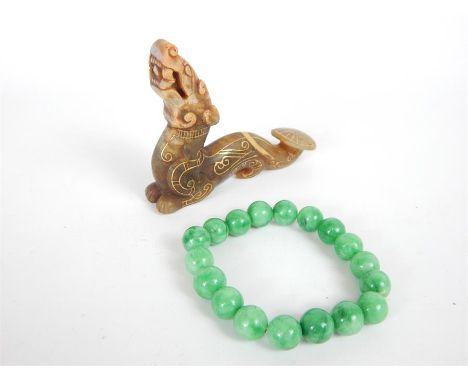 A green jade, beaded bracelet (7 cm) with a brown jade and gilt dragon figurine (6.5 x 8 cm) (2)
