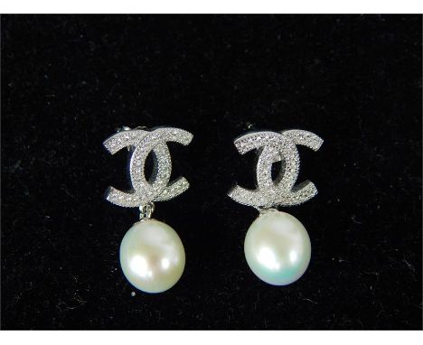 A pair of CZ and freshwater pearl earrings.