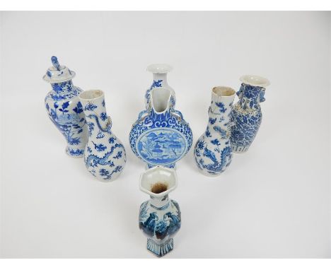 A collection of seven Chinese blue and white porcelain items, including a moon flask, a pair of jars with covers, and vases, 