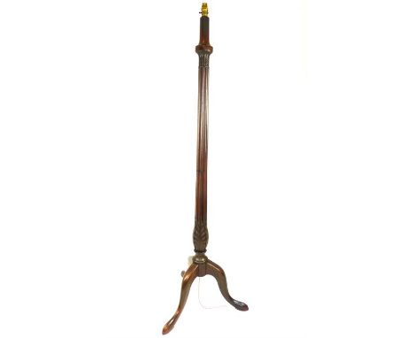 A fine, tall, carved, mahogany standing lamp on three, splayed legs, the tall lamp decorated with carved leaf details to the 