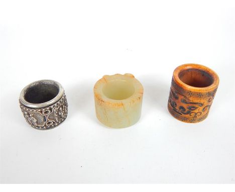 Three Chinese, archery rings made from green and orange jade featuring a carved central plaque, (Dia: 3.5 cm), a carved and s