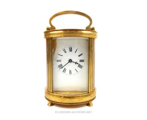 A 20th century gilt brass cylindrical carriage clock, having a rectangular white dial with black Roman numerals and visual pl