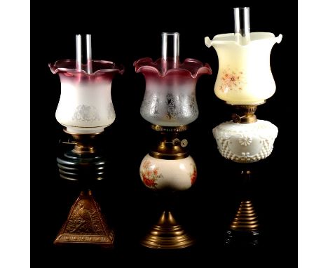 Four Victorian oil lamps, including one with moulded opaque glass reservoir, raised on brass fluted column, stepped base, one